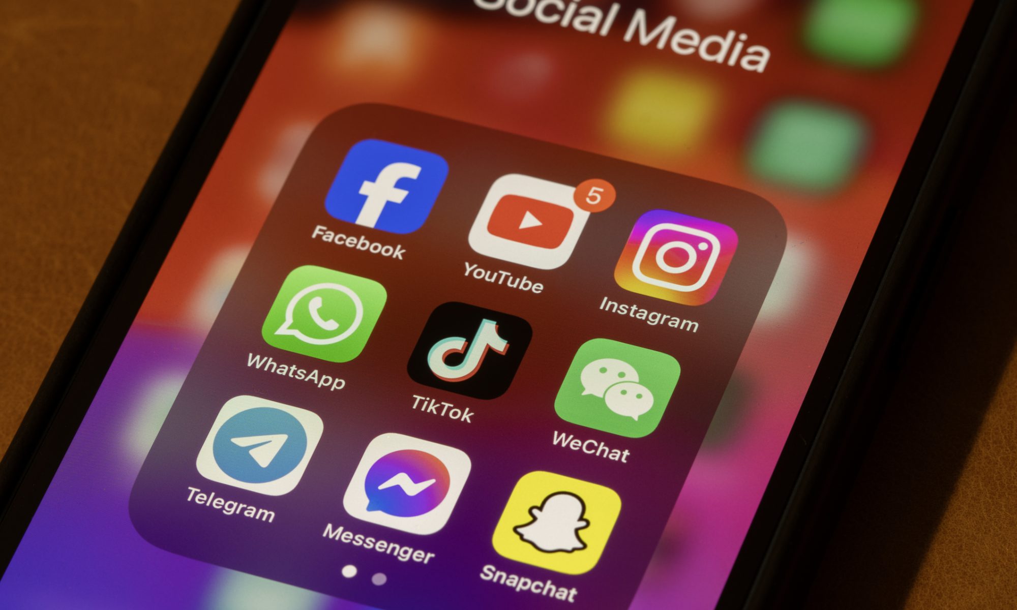 A smartphone screen displaying a folder labeled "Social Media" with popular app icons including Facebook, YouTube, Instagram, WhatsApp, TikTok, WeChat, Telegram, Messenger, and Snapchat.