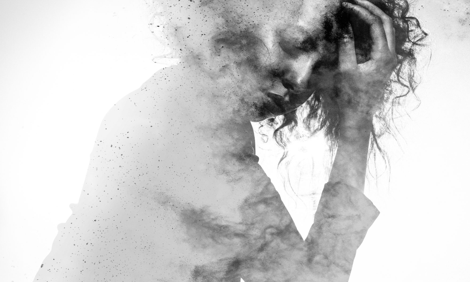 Abstract grayscale image symbolizing mental health struggles, showing a woman in emotional distress, partially dissolving into particles, representing the internal experience of anxiety and depression—relevant to Mind Medicine’s psychedelic therapy research.