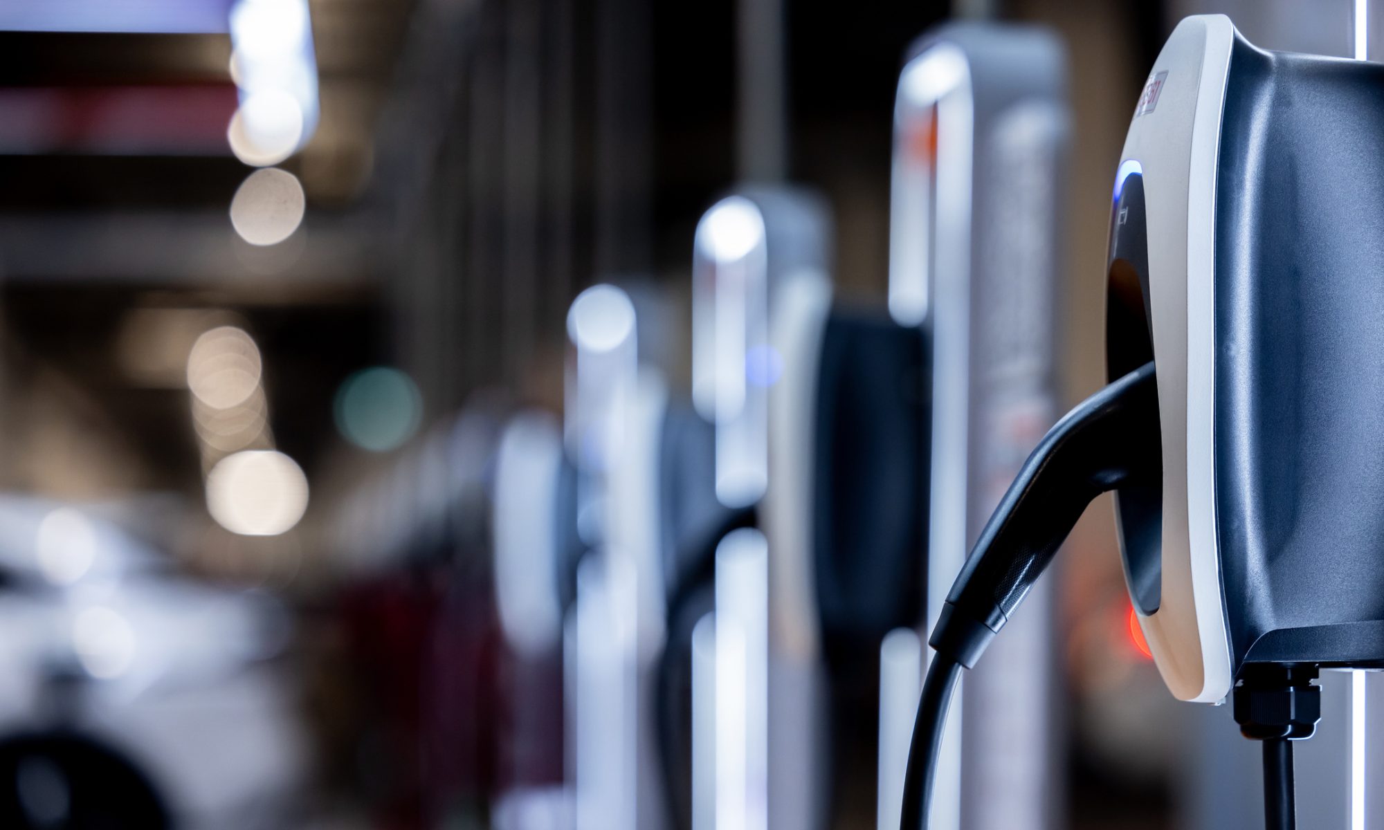 Electric vehicle charging stations lined up in a commercial parking facility, highlighting EV and energy infrastructure expansion.