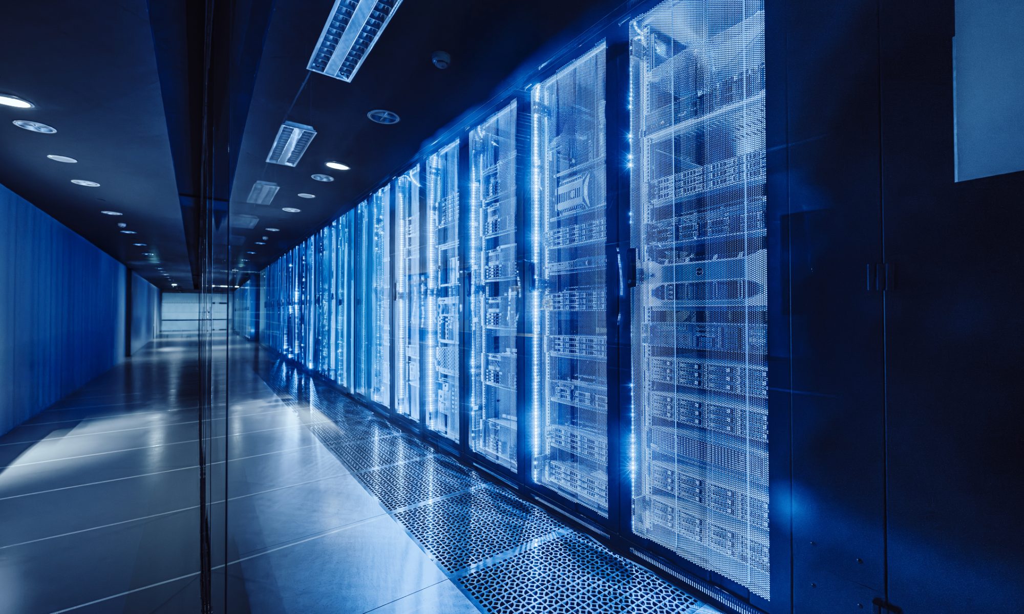 Blue-lit data center corridor with rows of high-density server racks, representing cloud infrastructure, AI workloads, and energy-efficient digital operations.