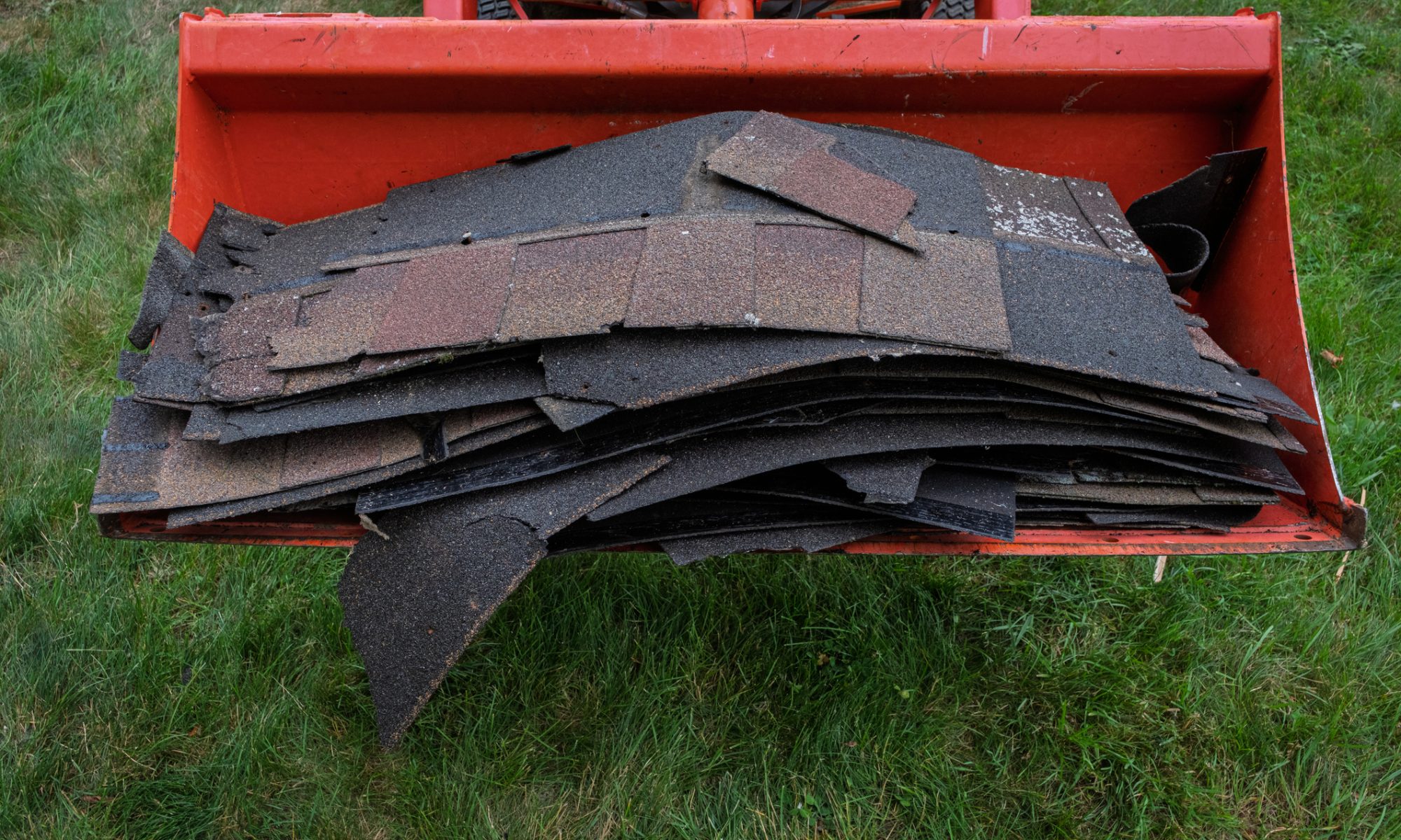 Industrial debris and recycled roofing materials loaded in construction equipment, representing sustainable waste processing and infrastructure development tied to NorthStar’s U.S. expansion.
