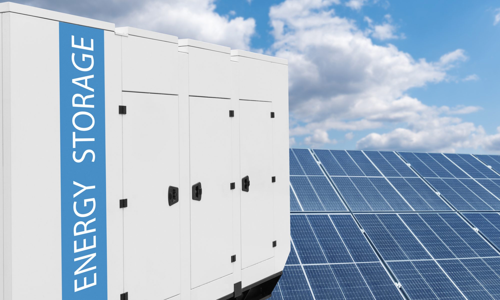 Utility-scale battery energy storage units installed alongside a solar panel array as part of a hybrid renewable energy project.