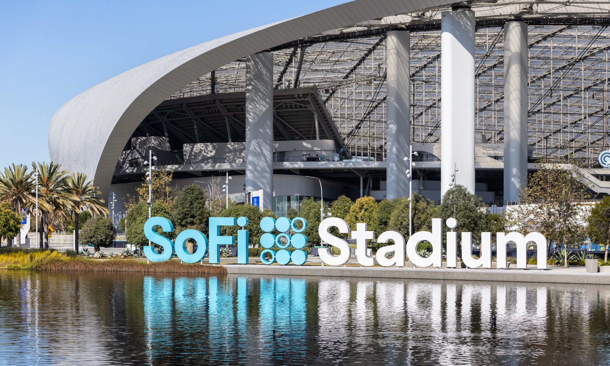 SoFi Stadium exterior in Los Angeles reflected in water, highlighting the fintech company’s brand as SoFi reports over $1 billion in quarterly revenue.