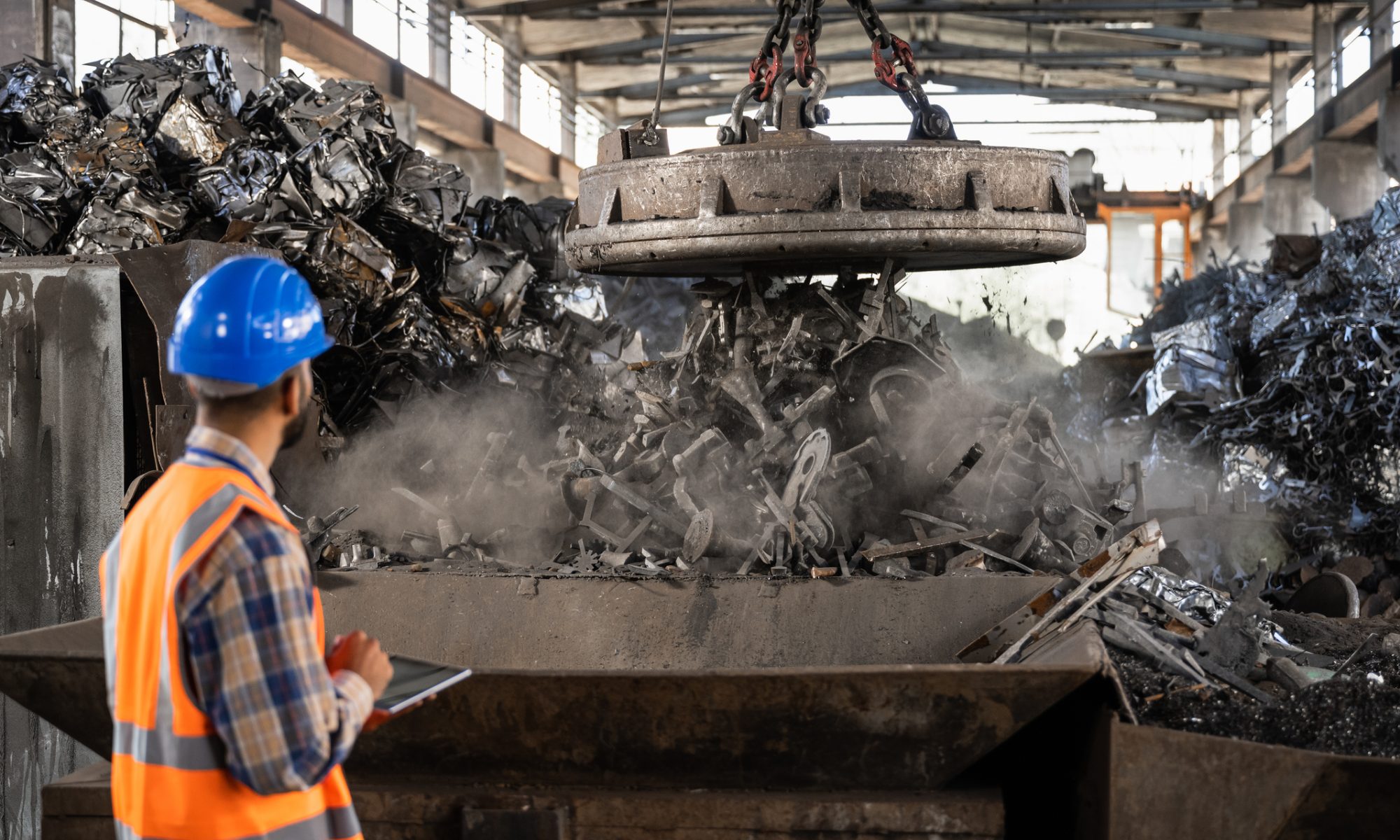 Industrial worker overseeing metal recycling operations inside a manufacturing facility, illustrating circular battery materials processing in the U.S.