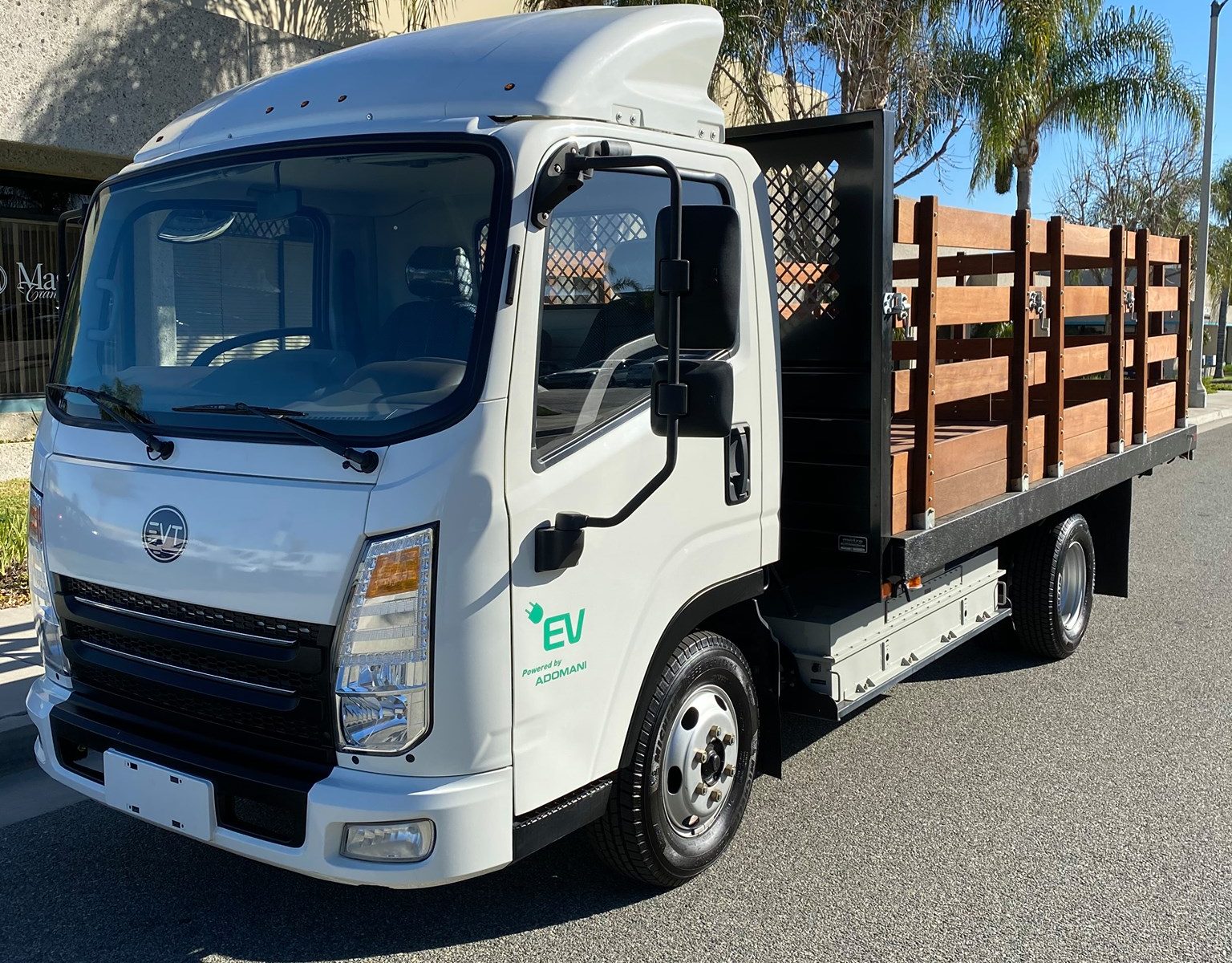 White Envirotech Vehicles electric commercial flatbed truck parked on a city street, highlighting the company’s zero-emission fleet platform and expansion into AI and compute infrastructure.