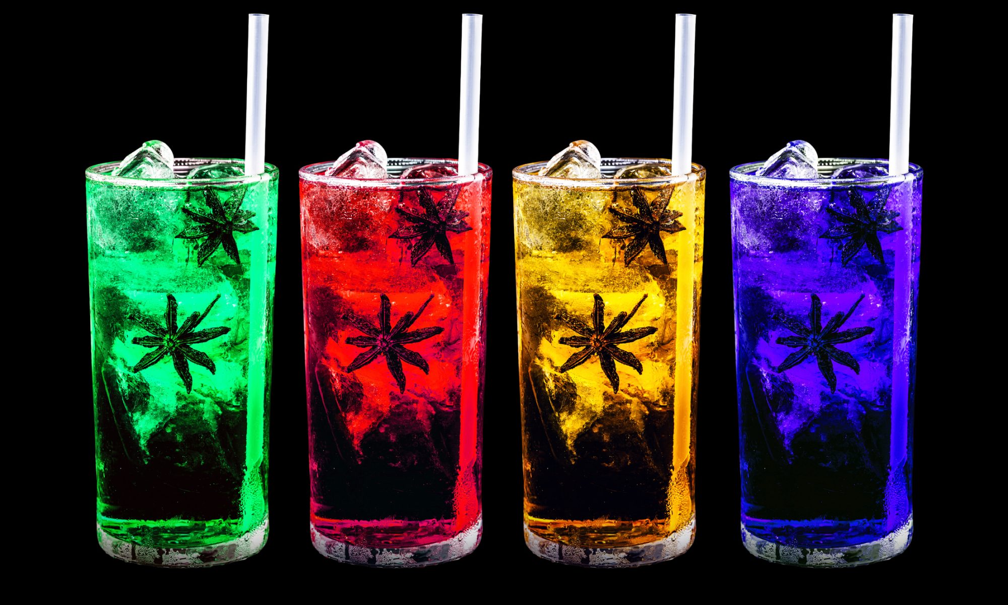 Four colorful cannabis-infused beverages in clear glasses—green, red, yellow, and purple—filled with ice, garnished with star anise, and served with straws against a black background.