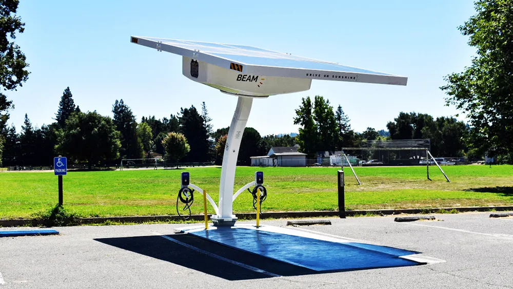 Solar-powered EV charging station installed in a parking area, featuring an overhead solar canopy and charging units.
