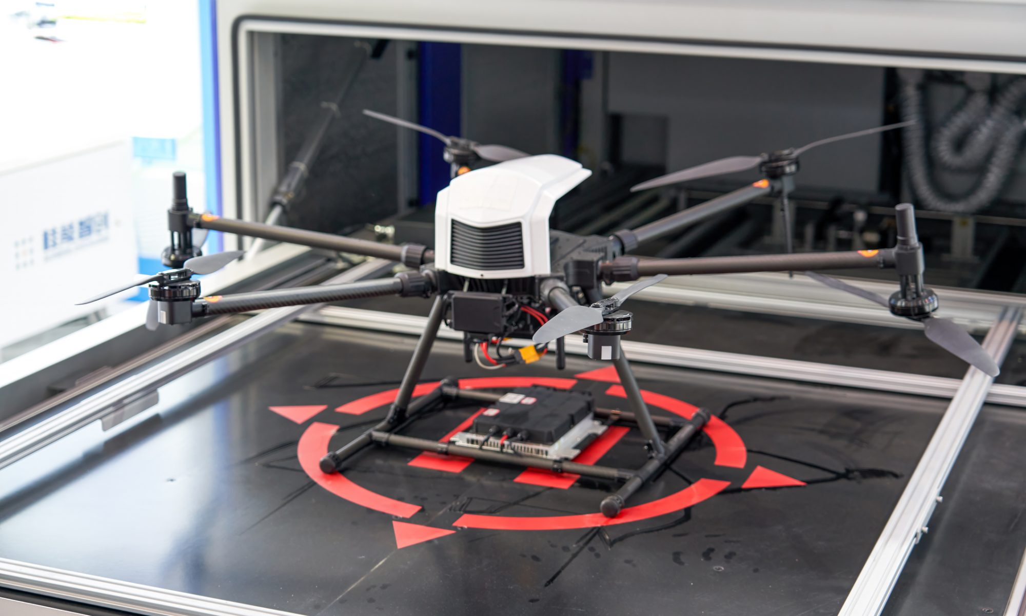 A professional industrial drone rests on a landing platform inside a testing facility, representing advanced unmanned aerial systems used for defense, infrastructure inspection, public safety, and industrial operations.