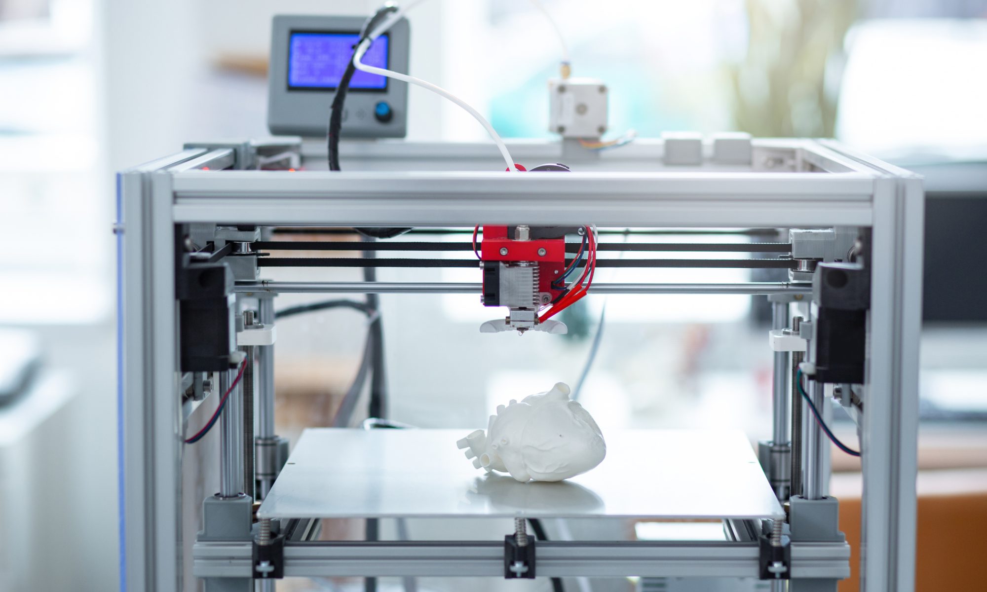 A 3D printer fabricates a detailed anatomical heart model in a modern laboratory, representing advanced medical manufacturing, healthcare innovation, and additive manufacturing technologies.