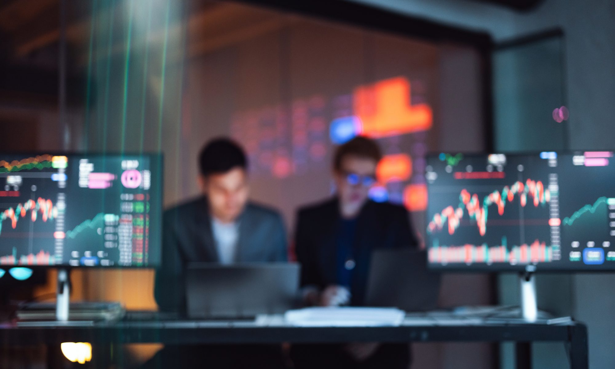 Stock-market trading screens displaying rising and falling price charts, representing PRISM Mid-Day Movers led by MedTech and cybersecurity stocks Neuronetics and Rapid7.