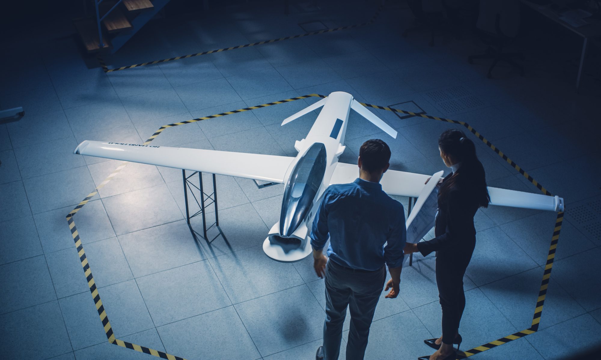 Aerospace engineers inspect an advanced aircraft prototype in a development facility, representing defense technology, strategic materials, and national security innovation.