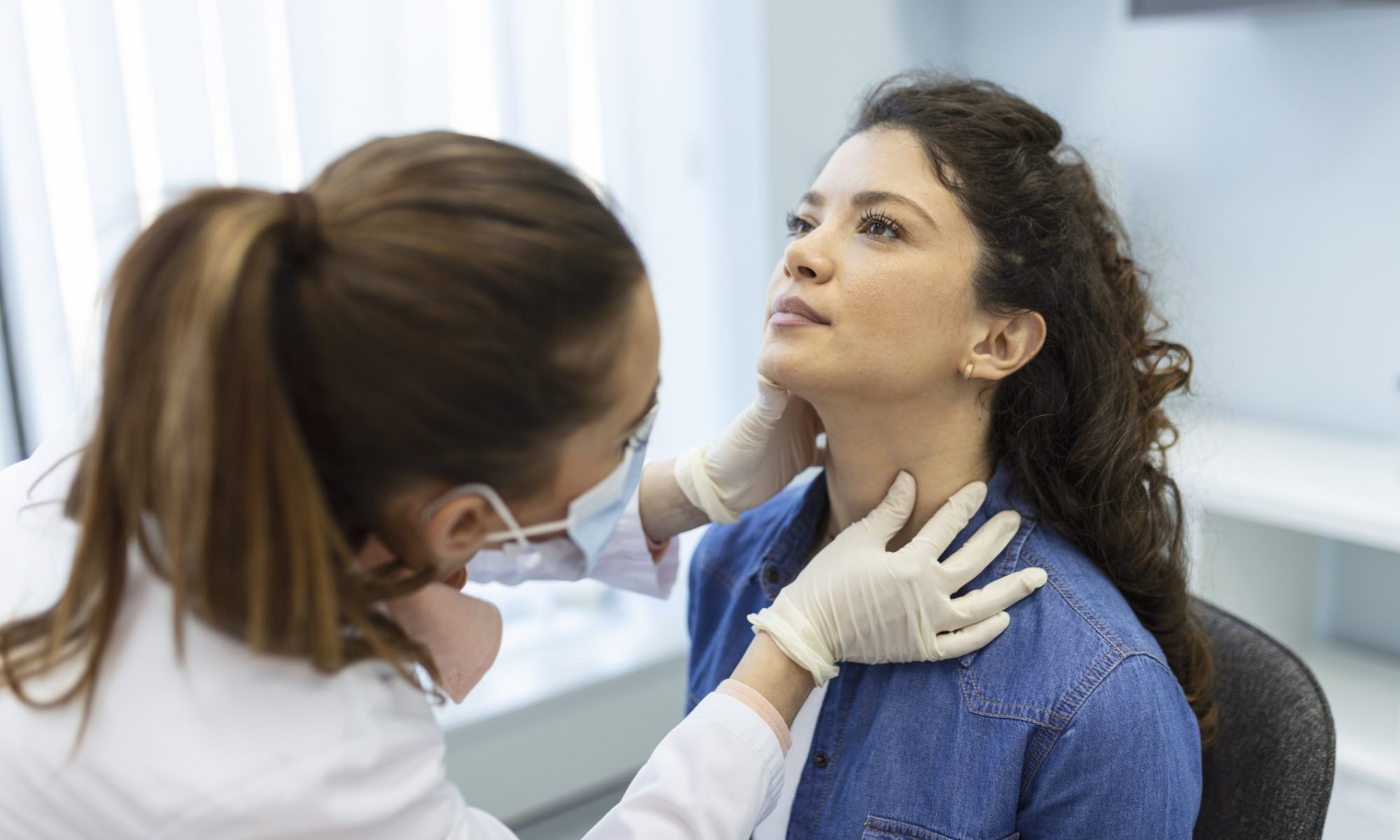 Healthcare professional examines a patient’s neck, representing clinical evaluation and Allogene Therapeutics’ development of cema-cel for large B-cell lymphoma.