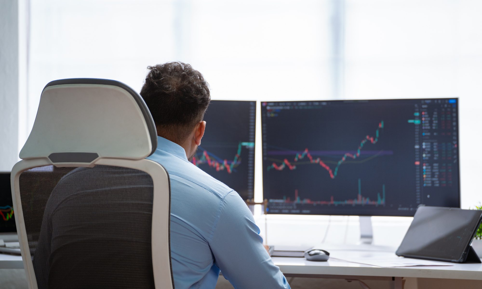 Investor monitors rising stock charts on multiple screens during an active trading session, illustrating strong market momentum in women’s health and electric vehicle stocks.