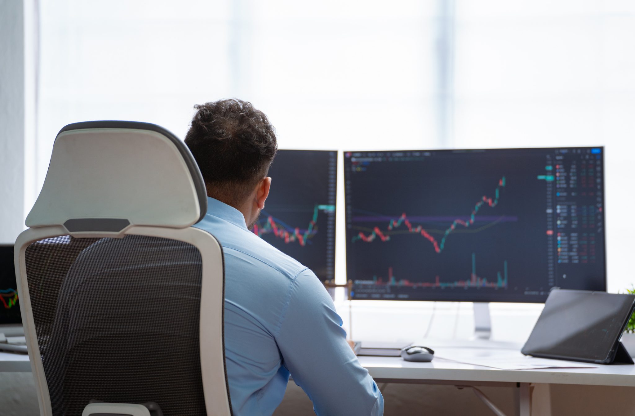 Investor monitors rising stock charts on multiple screens during an active trading session, illustrating strong market momentum in women’s health and electric vehicle stocks.
