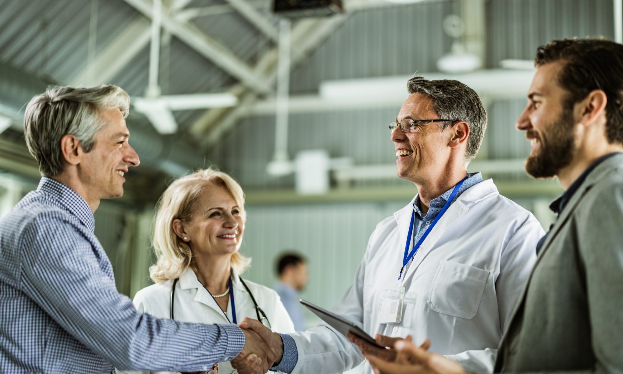 Biotechnology executives and researchers meeting in a laboratory setting, representing Skye Bioscience’s planned acquisition of Redx Pharma and the formation of Fibrx Therapeutics.