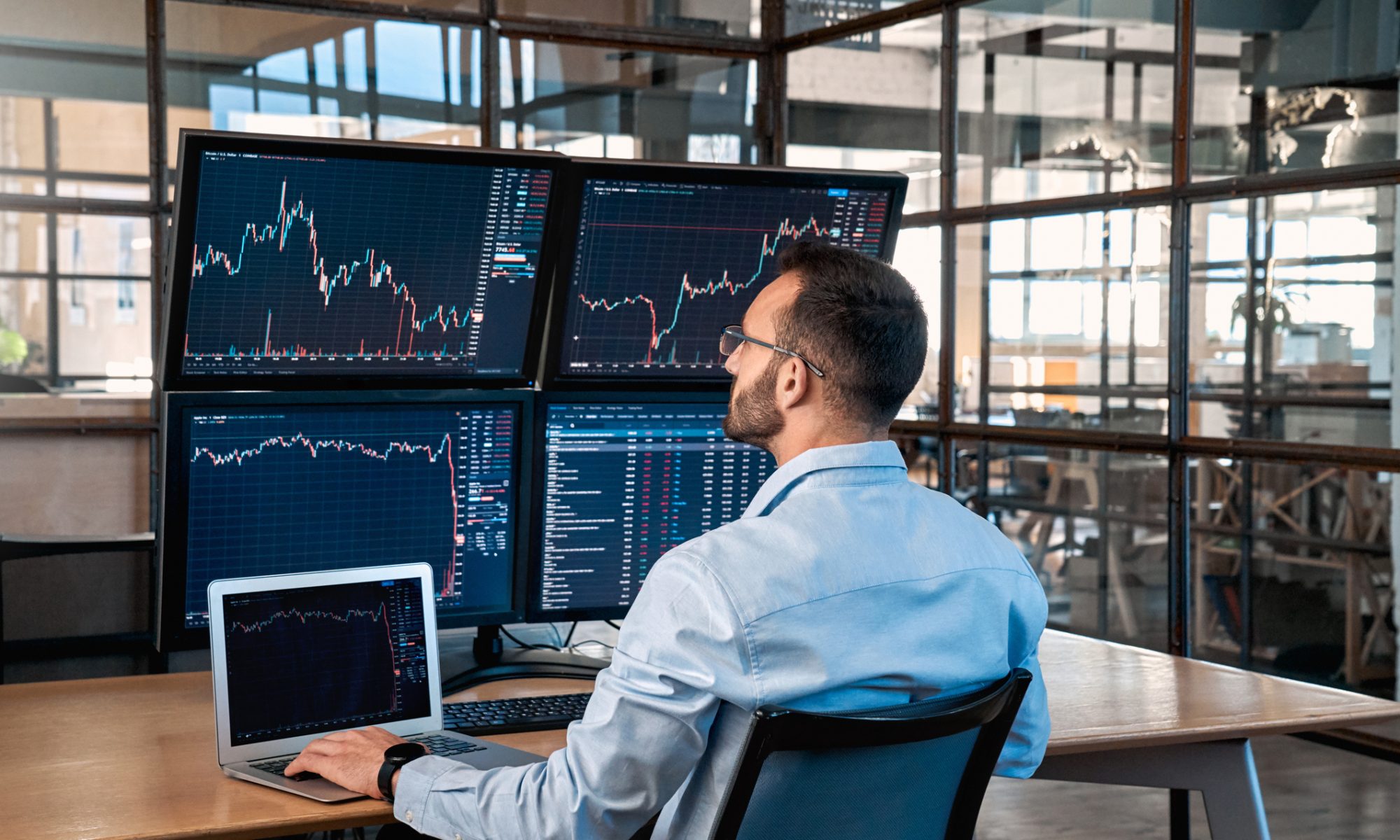Investor monitoring multiple stock-market charts on computer screens, representing strong mid-day trading activity in pharmaceutical and MedTech stocks including Amylyx Pharmaceuticals and bioAffinity Technologies.
