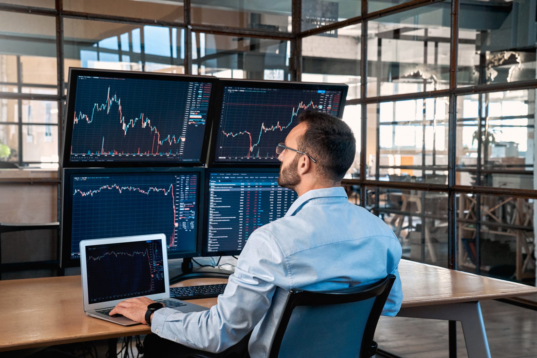 Investor monitoring multiple stock-market charts on computer screens, representing strong mid-day trading activity in pharmaceutical and MedTech stocks including Amylyx Pharmaceuticals and bioAffinity Technologies.