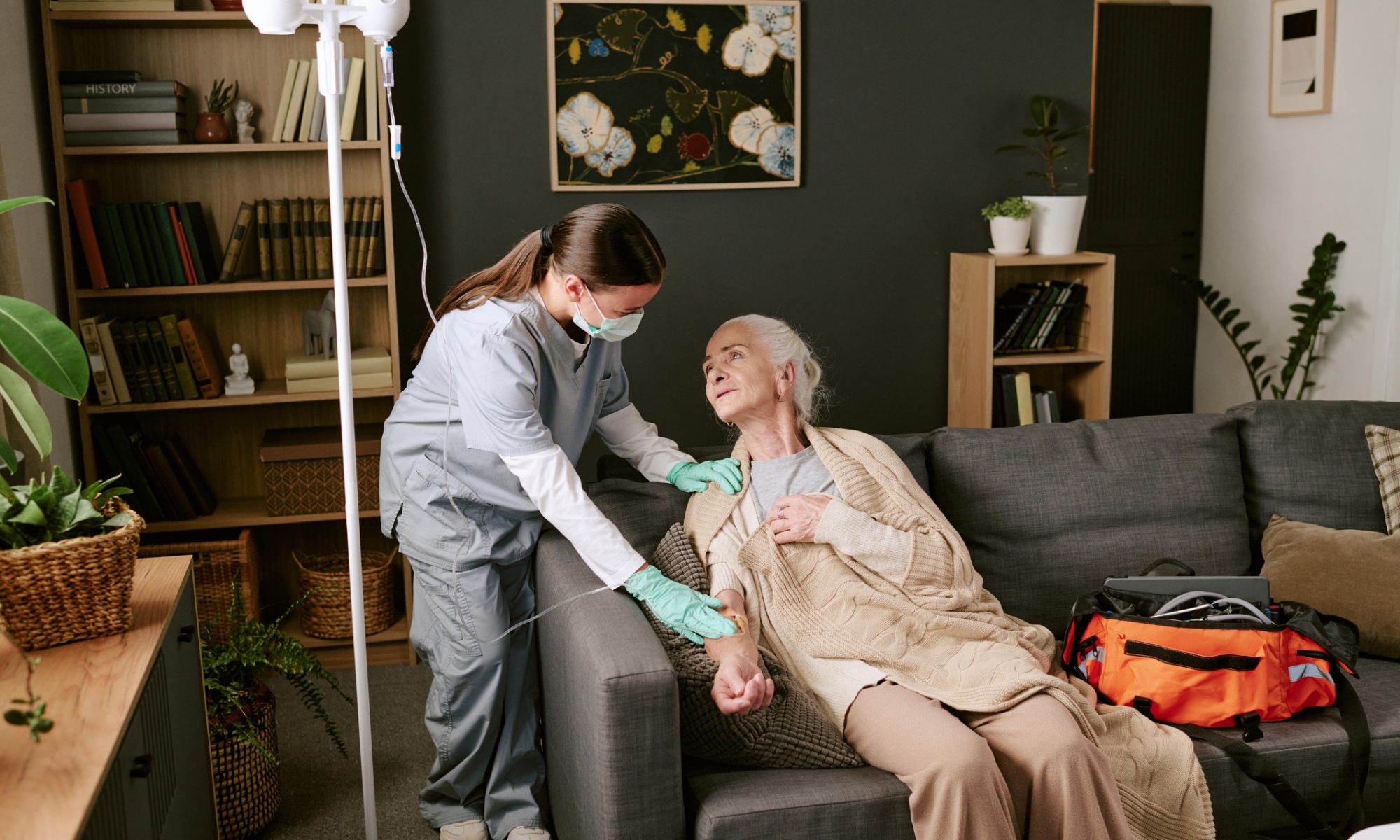 Home infusion nurse assists an older patient receiving IV therapy at home, illustrating CareCloud’s AI-powered healthcare technology project with KabaFusion.