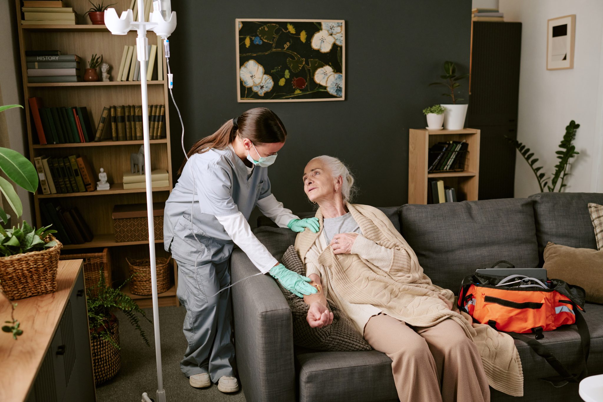 Home infusion nurse assists an older patient receiving IV therapy at home, illustrating CareCloud’s AI-powered healthcare technology project with KabaFusion.