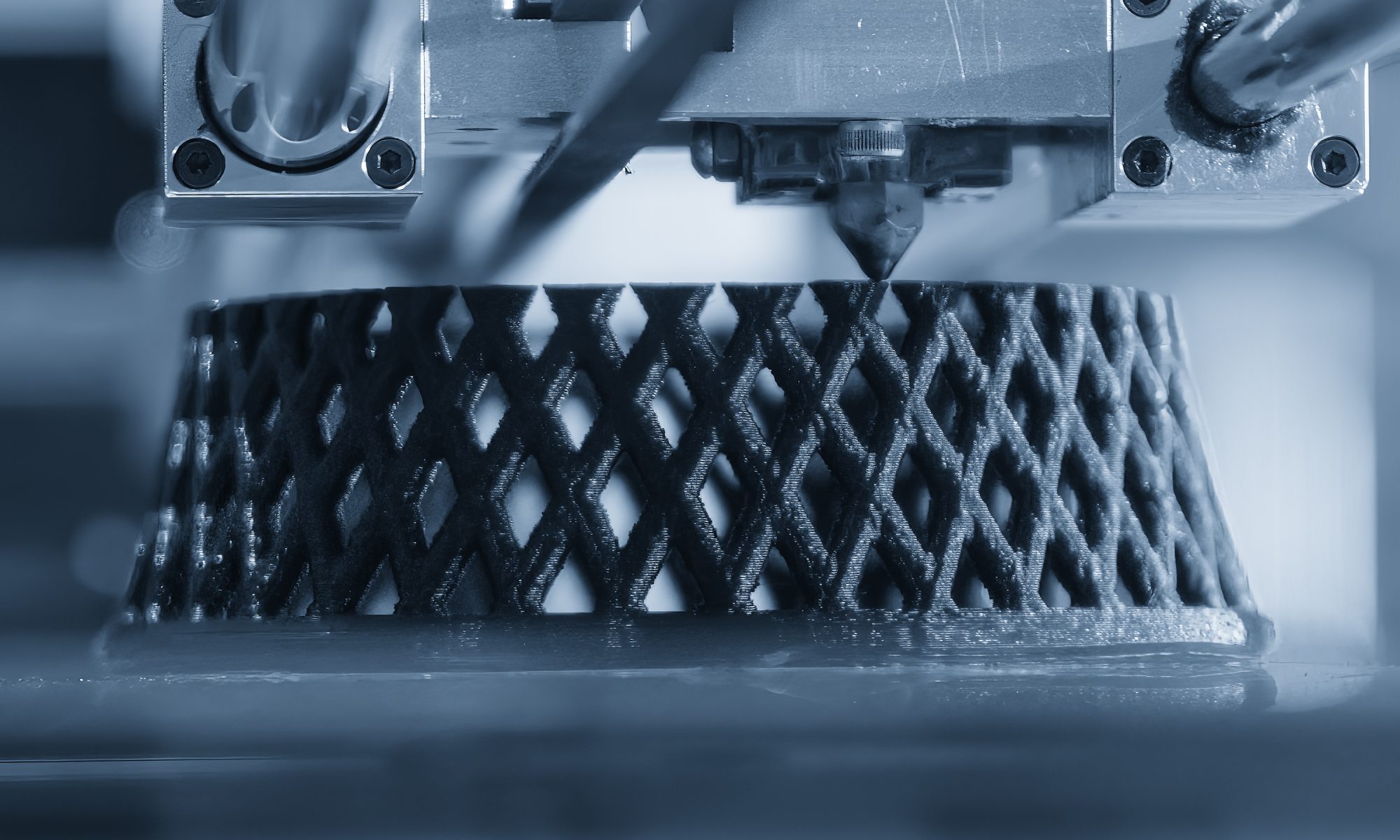 Industrial 3D printer producing a complex lattice component, representing advanced additive manufacturing for nuclear energy and resilient energy infrastructure.