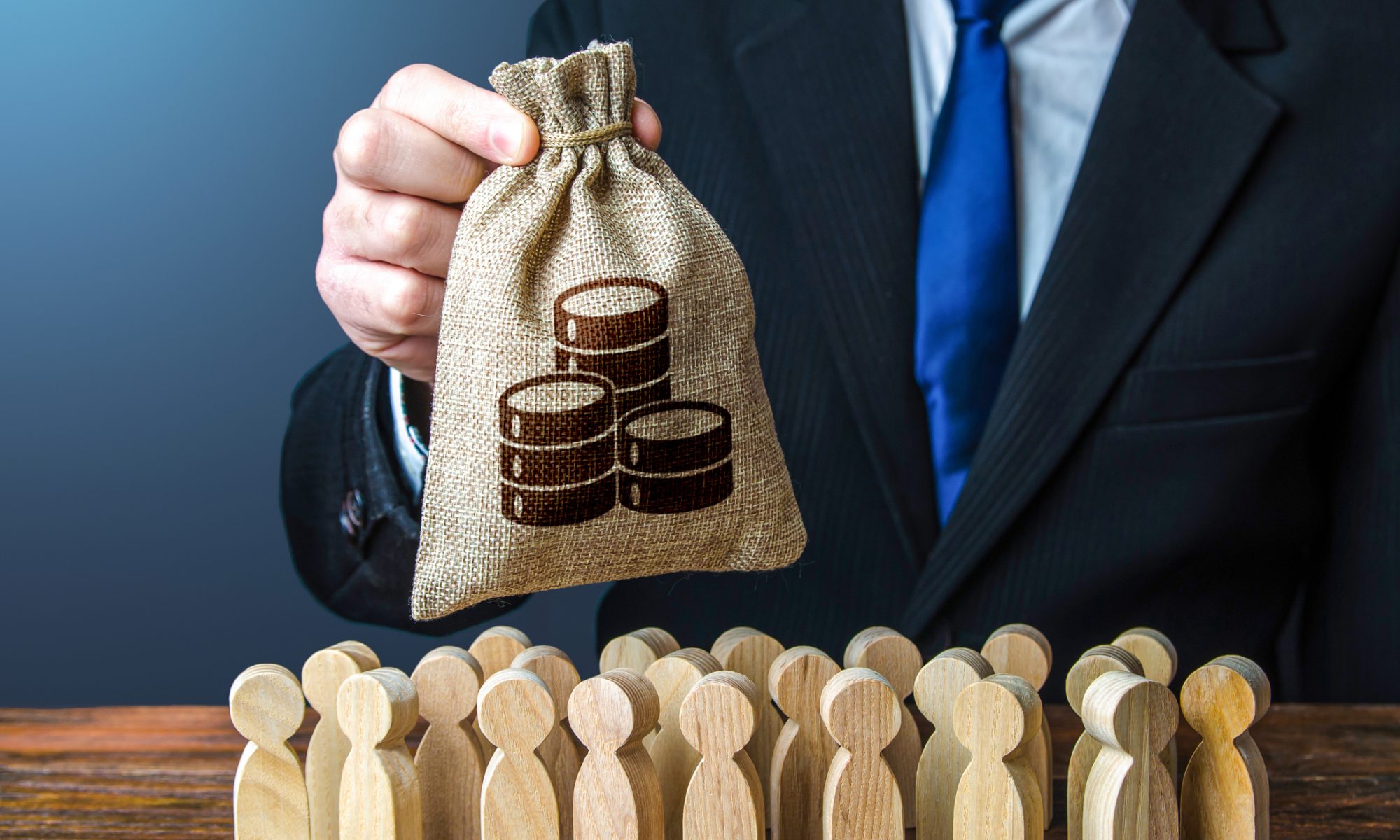 Business executive holds a money bag above a group of wooden figures, representing Biomerica’s $2.23 million financing and ongoing review of strategic alternatives.