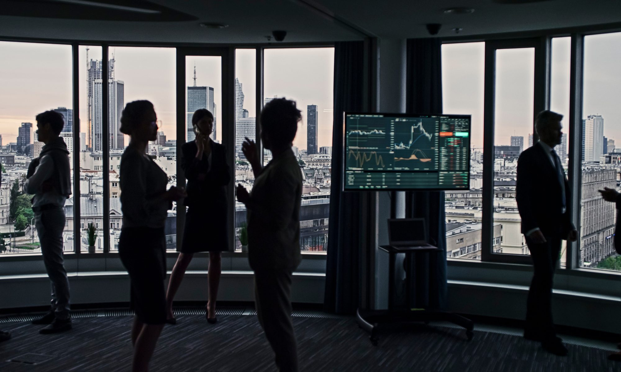 Business professionals gather near a digital market-data display, representing active stock trading as MedTech and pharmaceutical companies lead PRISM’s mid-day movers.
