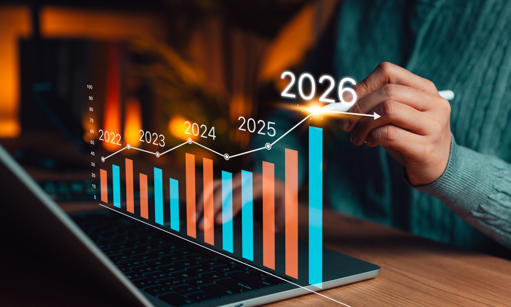 Person reviews a rising 2026 financial chart on a laptop, representing Numinus Wellness’ quarterly revenue growth and expanding practitioner-training business.