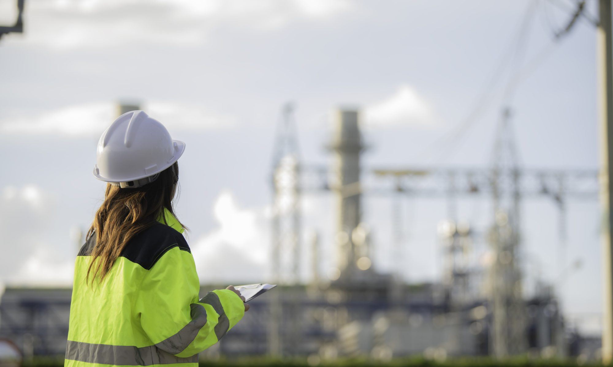 Engineer in safety gear inspects an industrial energy facility, representing Lightbridge’s DOE-supported efforts to advance nuclear fuel testing and commercialization.