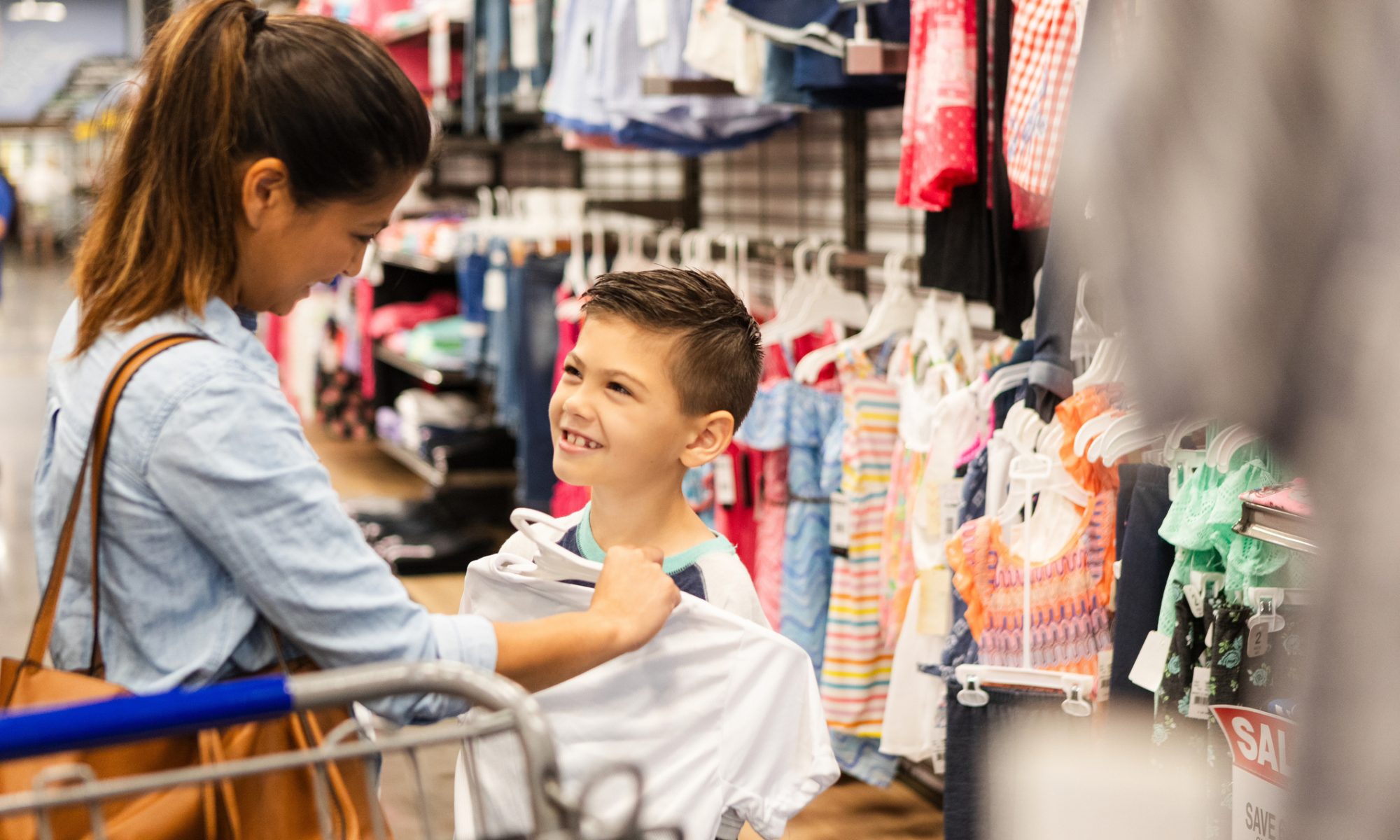 Mother and child shop for clothing in a retail store, illustrating Carter’s efforts to reshape its North American store footprint and focus on stronger locations.