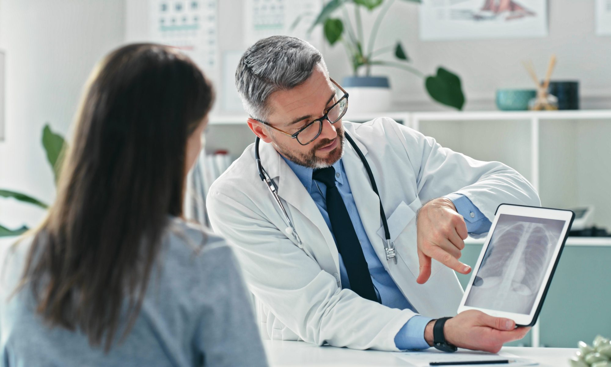 Doctor reviews a lung scan with a patient, representing bioAffinity Technologies’ efforts to expand CyPath Lung for monitoring lung cancer survivors after treatment.