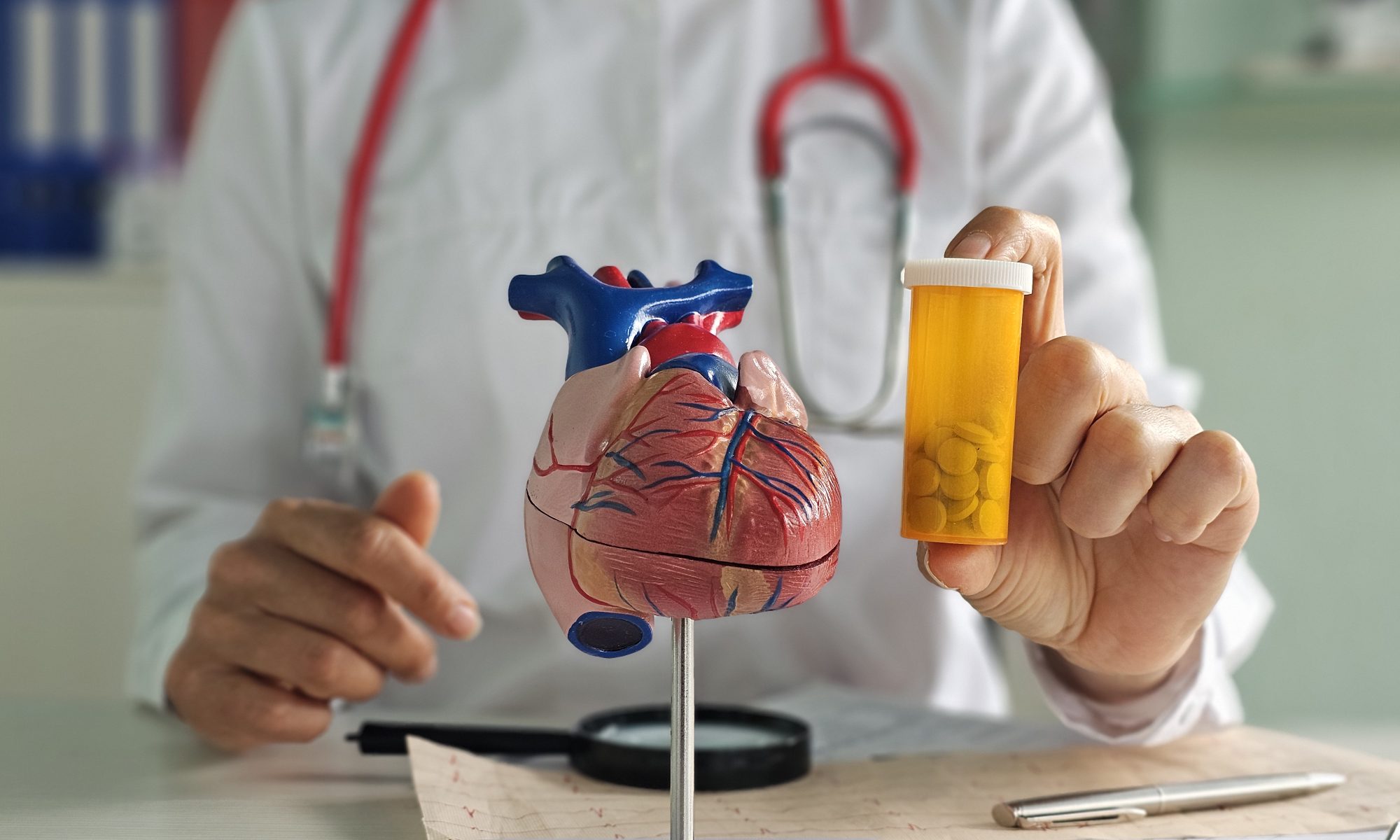 Doctor holding a heart model and prescription bottle, illustrating cardiovascular drug development and Cardiol Therapeutics’ CardiolRx program.