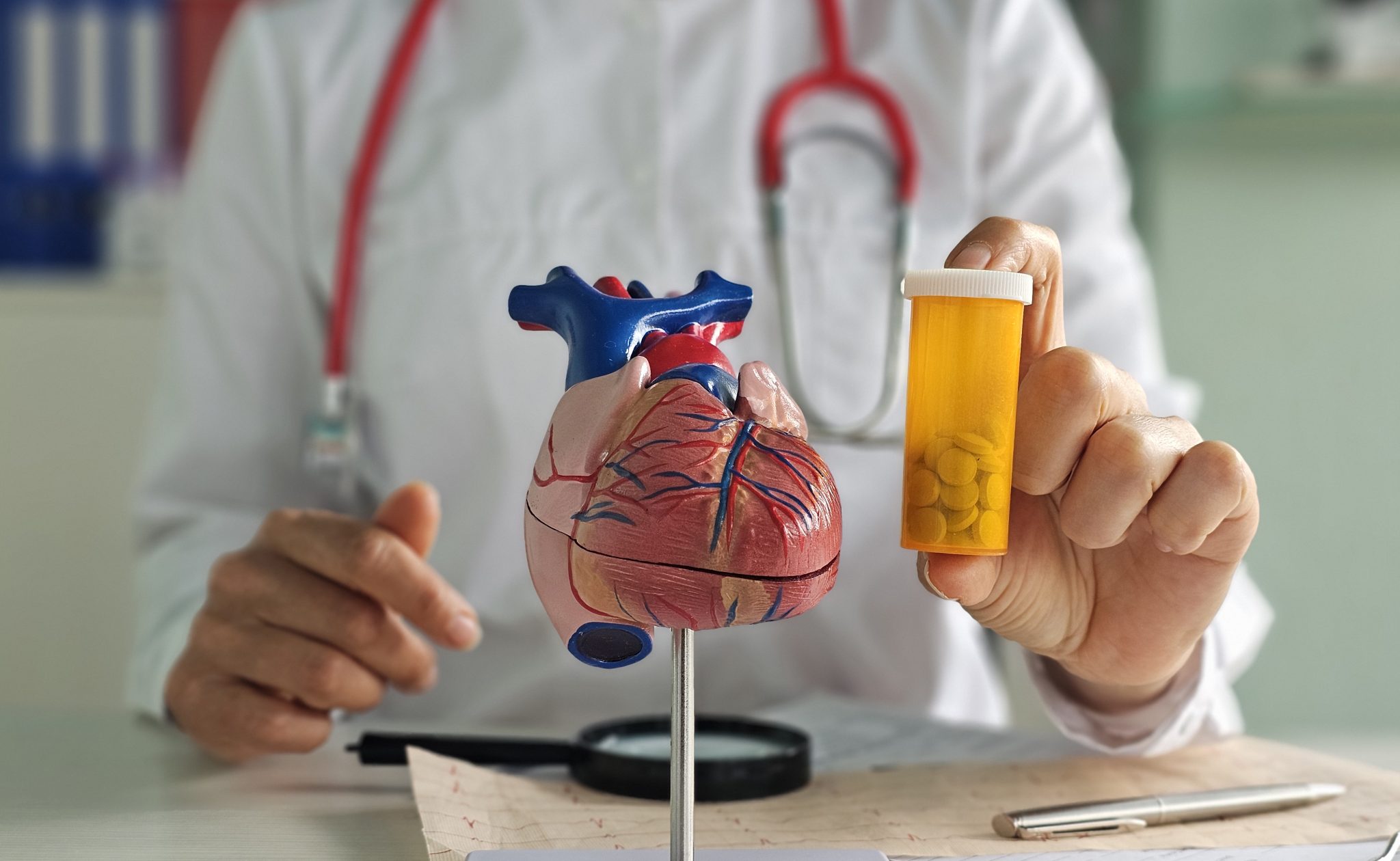 Doctor holding a heart model and prescription bottle, illustrating cardiovascular drug development and Cardiol Therapeutics’ CardiolRx program.