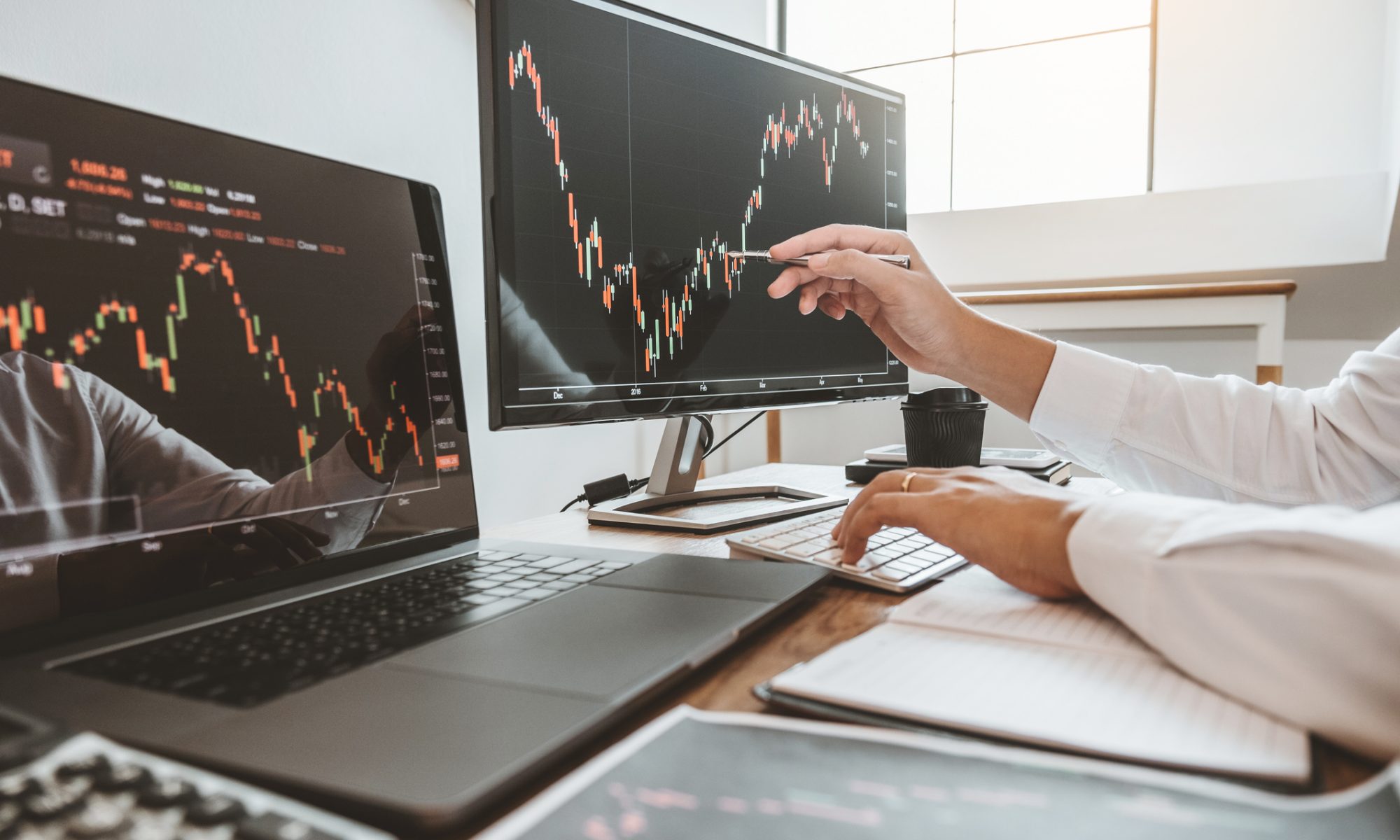 Market analyst reviewing stock charts across multiple screens, representing PRISM Mid-Day Movers in women’s health and aerospace and defense.