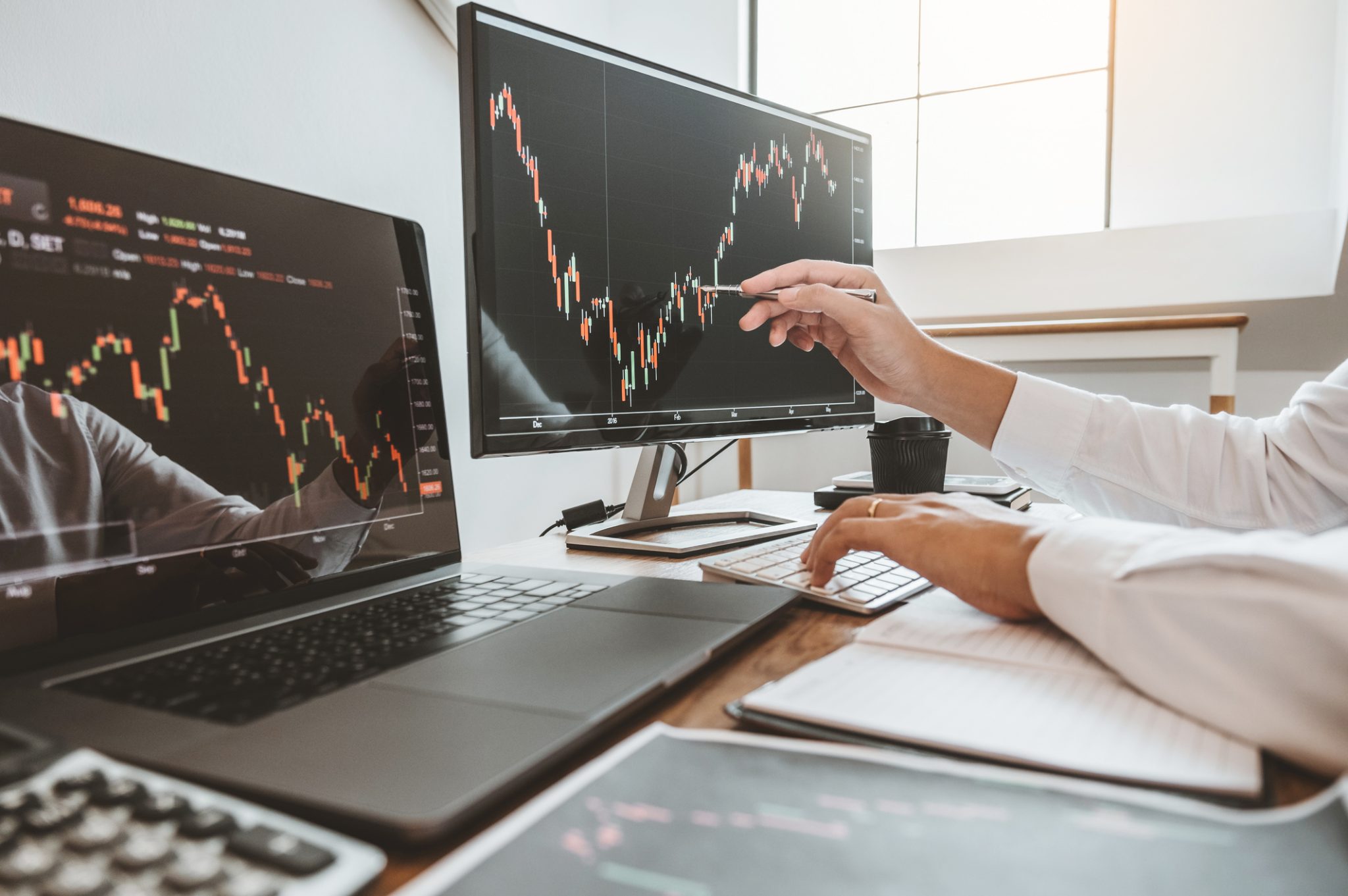 Market analyst reviewing stock charts across multiple screens, representing PRISM Mid-Day Movers in women’s health and aerospace and defense.