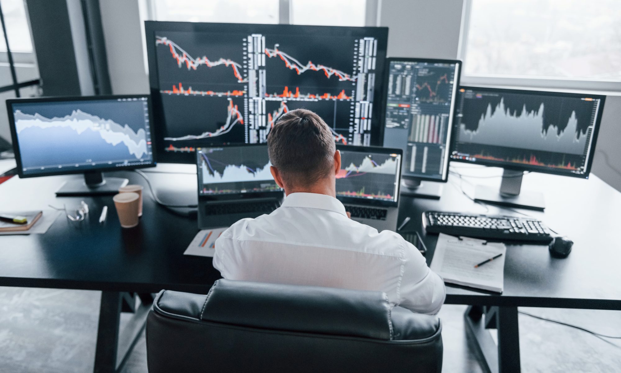 Trader monitors multiple stock charts as Canaan and Viant Technology lead PRISM Mid-Day Movers.