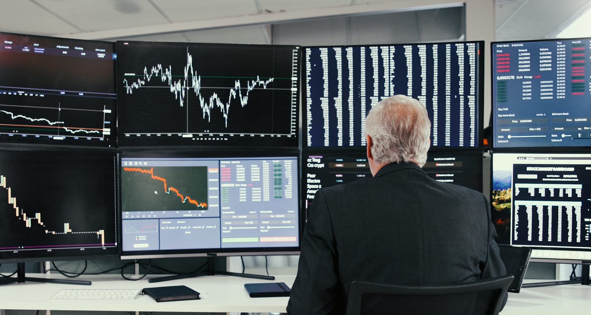 Trader monitors multiple financial market screens as stocks post sharp intraday moves across precious metals, fintech, energy and semiconductor sectors.