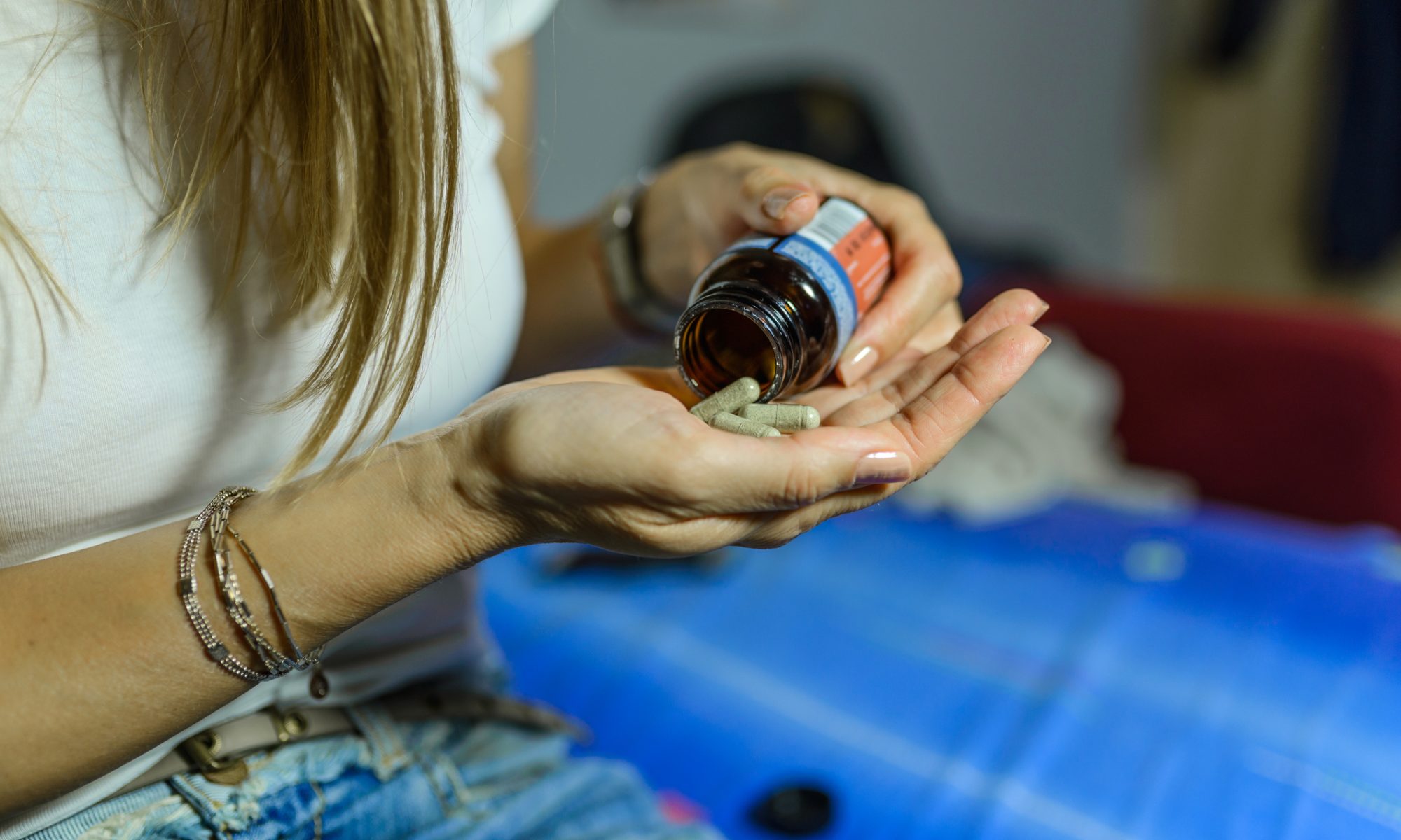 Person pouring capsules from a medicine bottle into their hand, representing Psyence BioMed’s planned pharmaceutical-grade ibogaine development program.