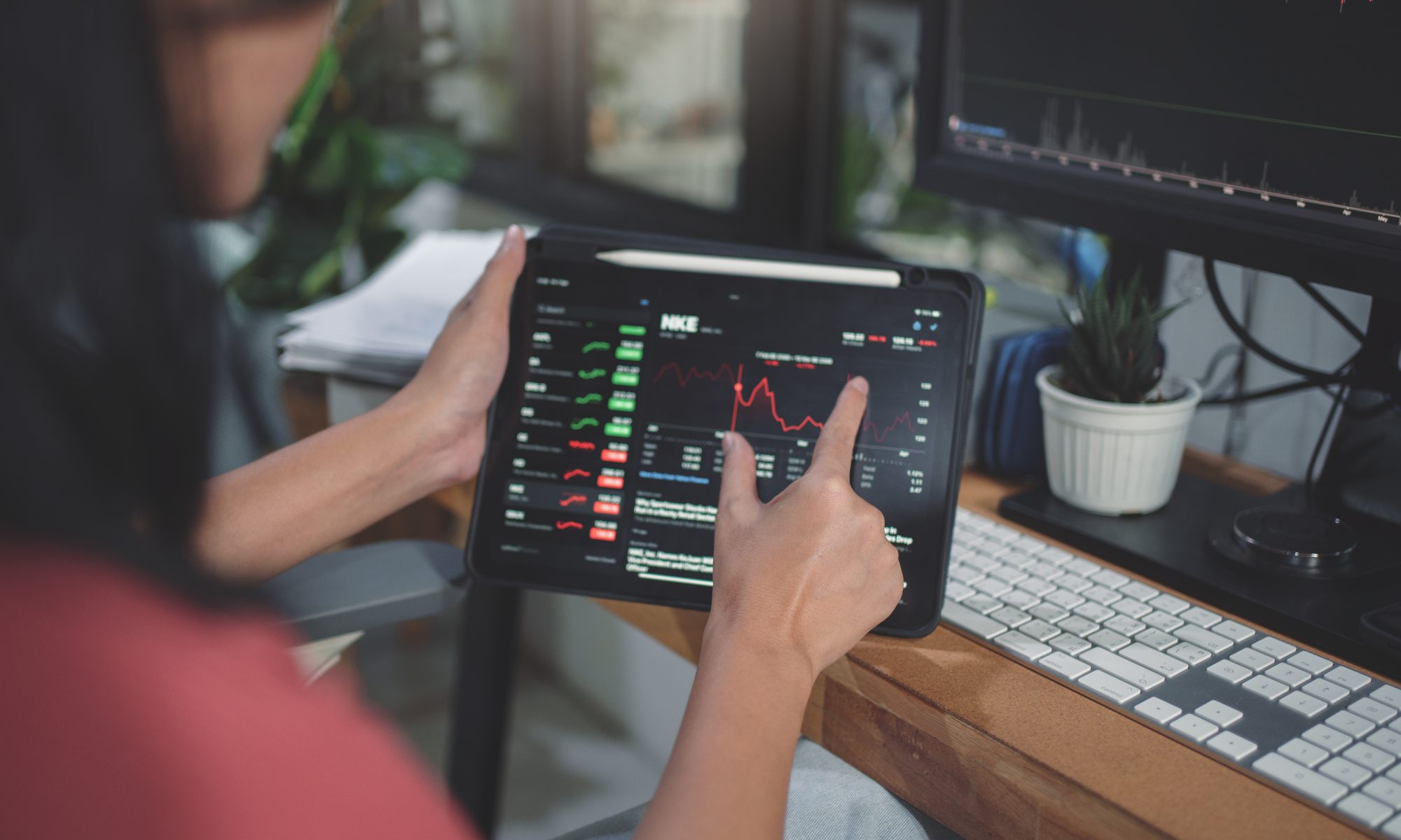 Investor monitoring stock charts on a tablet and desktop screen, representing active trading in Surrozen, Sky Quarry and other mid-day market movers.