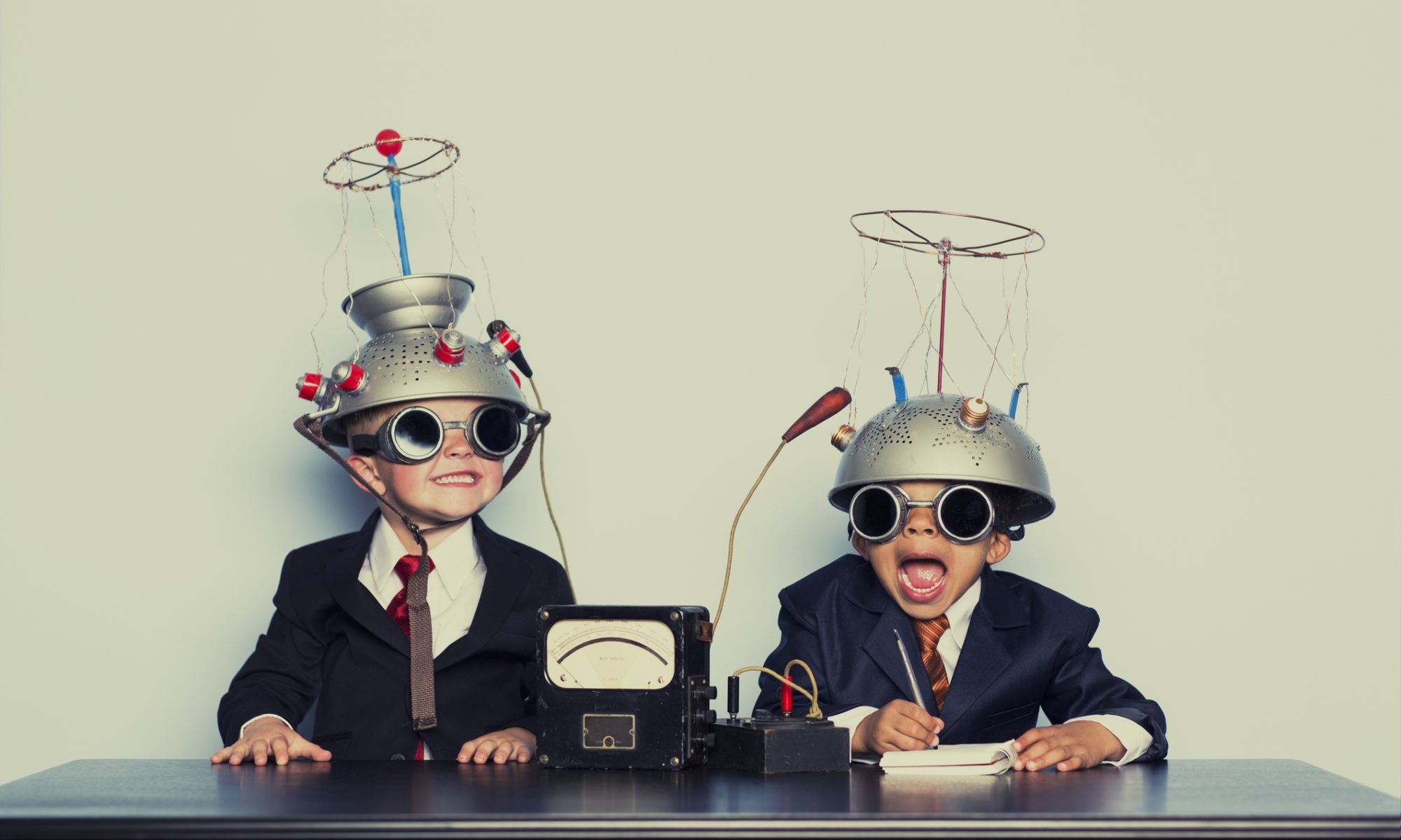 Two children wearing playful science-inspired headgear and goggles, representing non-drug neurotechnology and innovation in pediatric ADHD treatment.