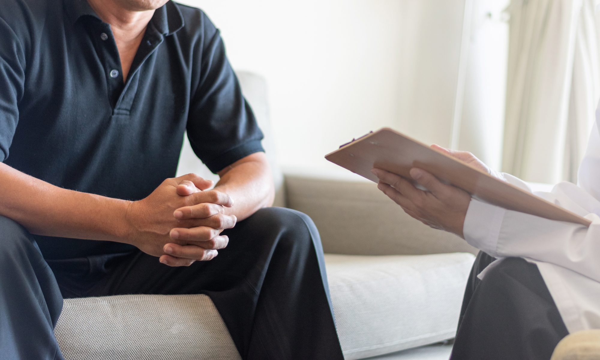 Patient speaking with a healthcare professional during a medical consultation, representing clinical research and treatment development for HPV-related cervical conditions.