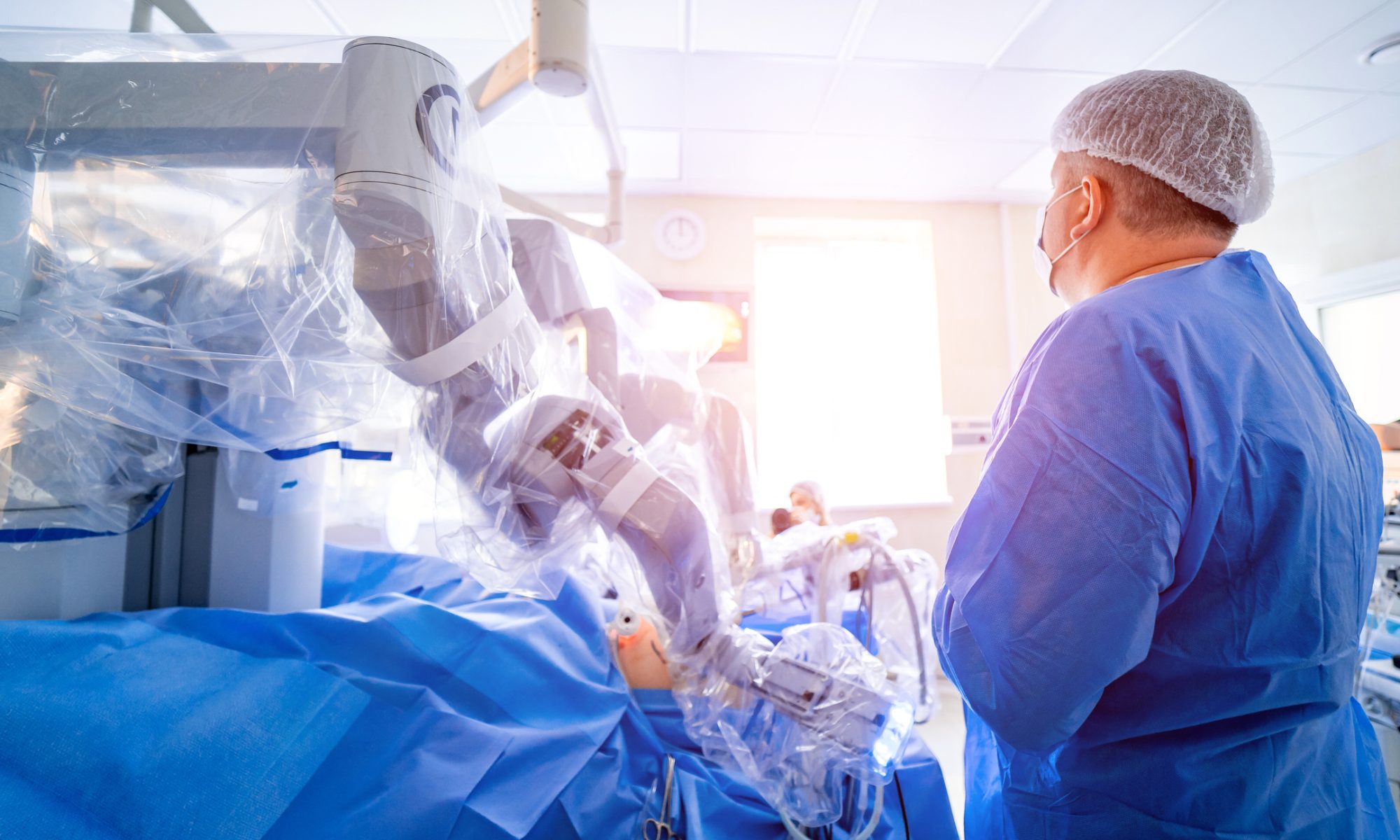 Surgeon operating a robotic-assisted medical system in a hospital operating room, representing Microbot Medical’s expansion of its LIBERTY robotic technology.