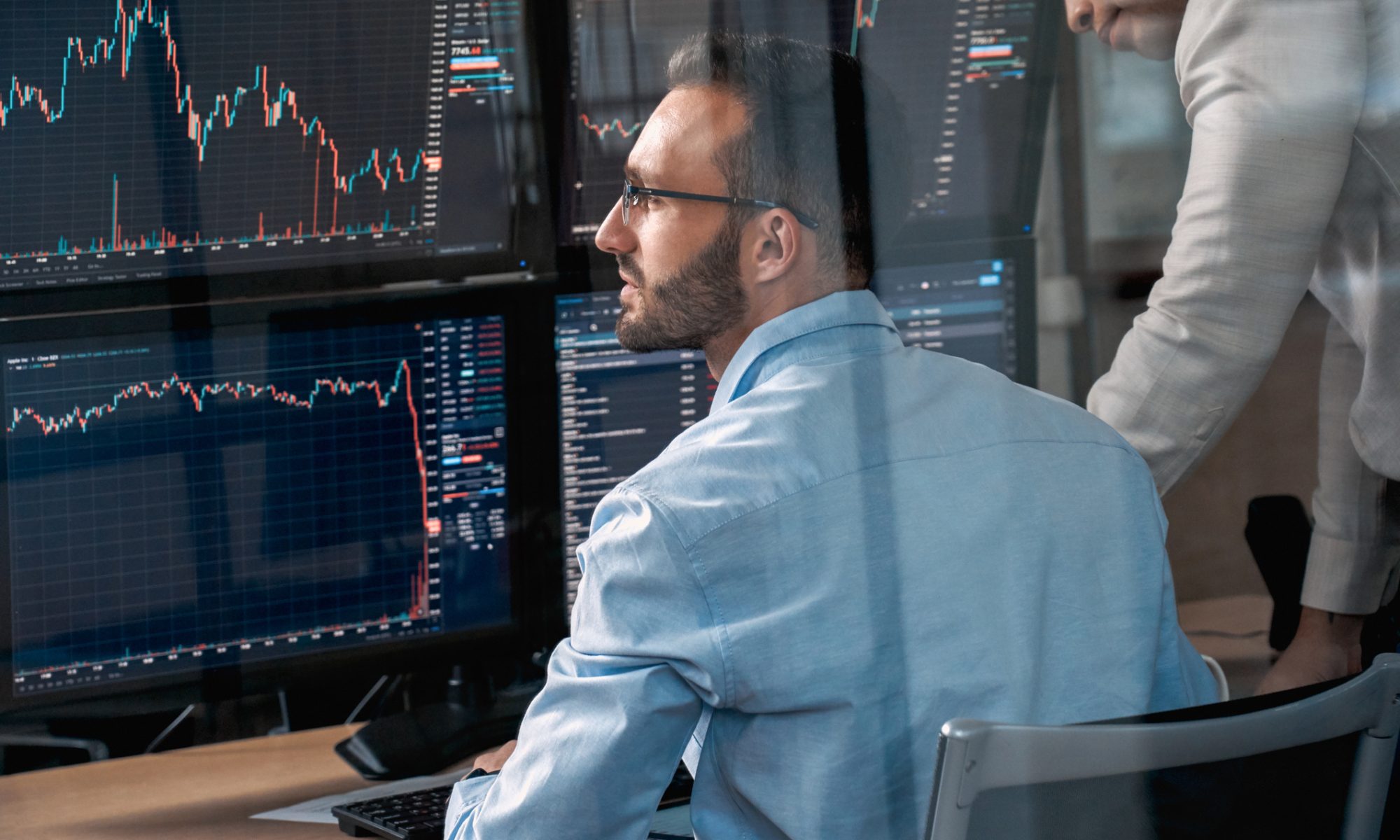 Financial professionals monitor multiple stock-market charts and trading screens, representing active midday market movers.