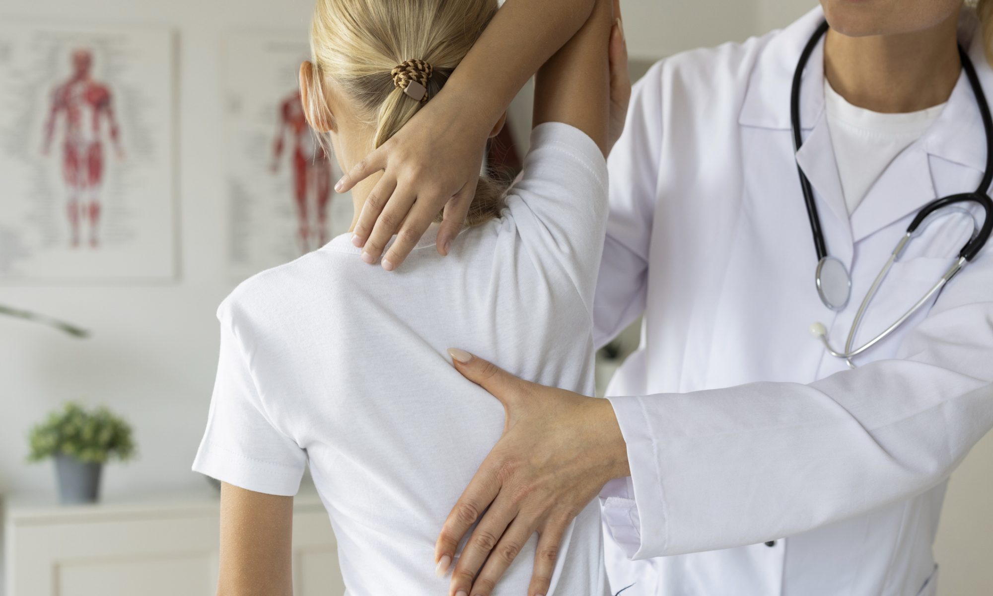 Healthcare professional examines a patient’s shoulder and upper back during a musculoskeletal assessment.