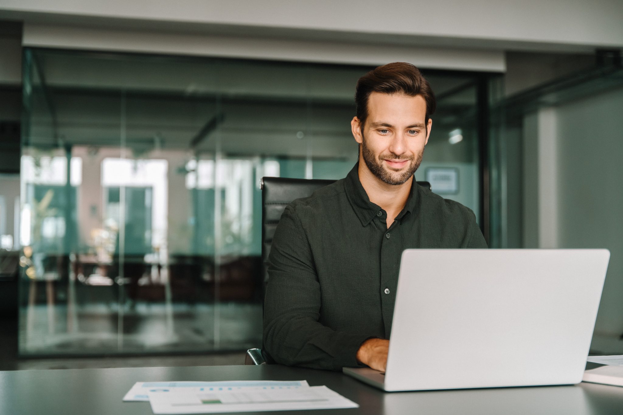 A professional works on a laptop in a modern office, representing high-performance computing and next-generation business technology.