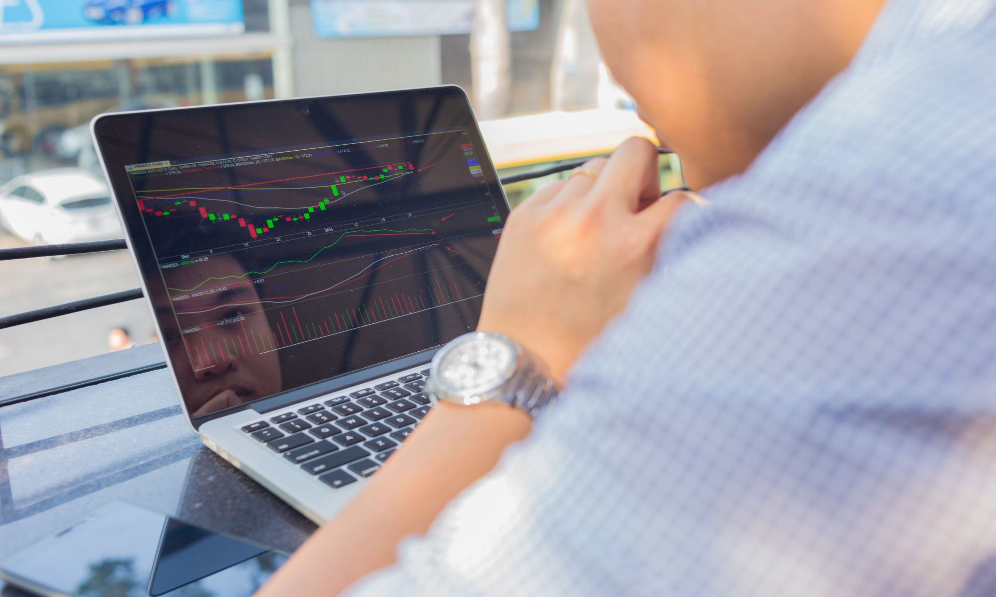 Investor analyzing stock market charts and trading activity on a laptop, illustrating midday market movements and financial trends.