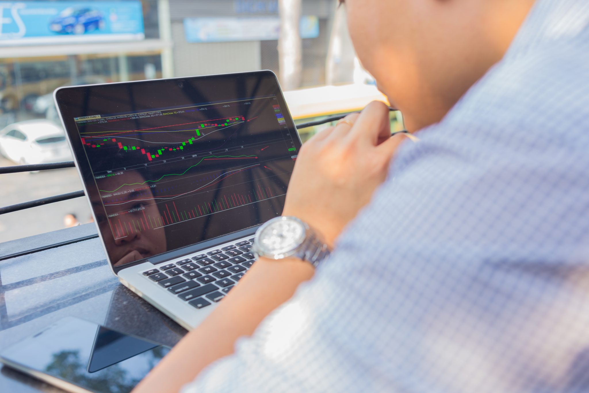 Investor analyzing stock market charts and trading activity on a laptop, illustrating midday market movements and financial trends.