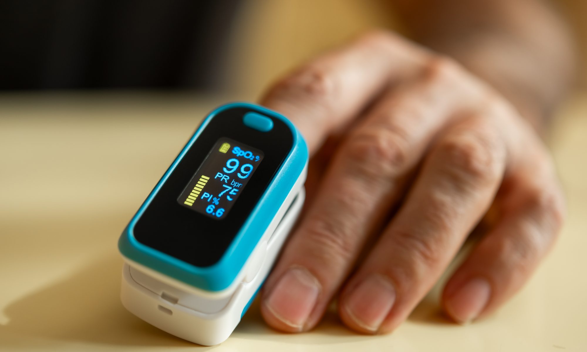 Close-up of a fingertip pulse oximeter measuring blood oxygen saturation and pulse rate, highlighting medical monitoring technology and early health detection.