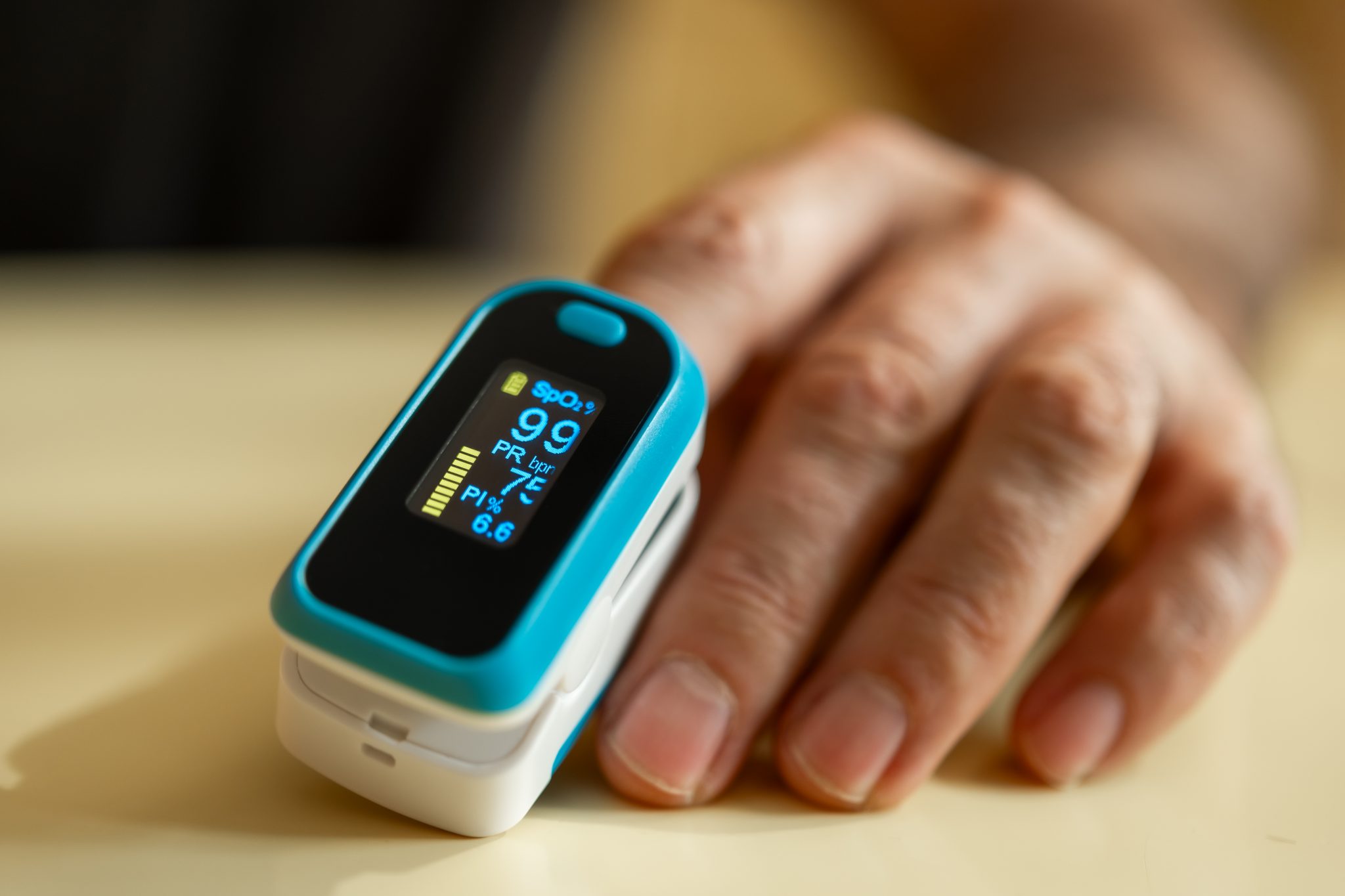Close-up of a fingertip pulse oximeter measuring blood oxygen saturation and pulse rate, highlighting medical monitoring technology and early health detection.
