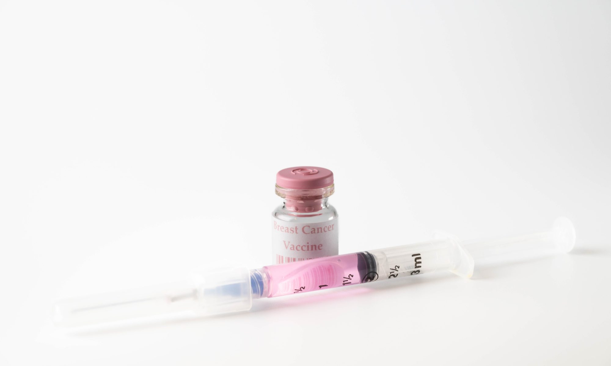 Small vial labeled "Breast Cancer Vaccine" with a syringe containing pink liquid against a clean white background, representing breast cancer immunotherapy research.
